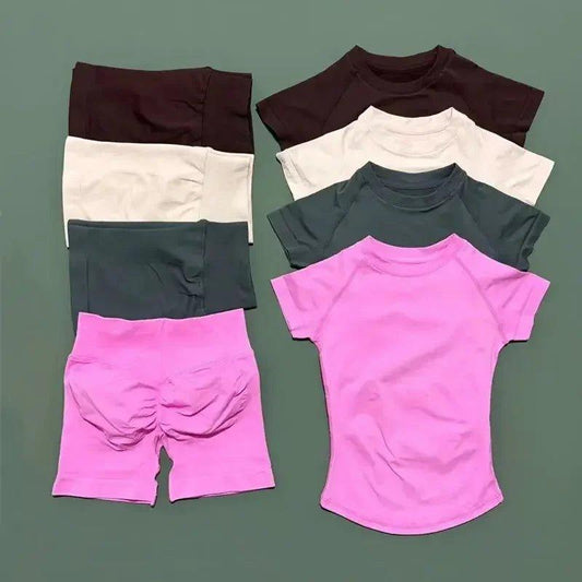 Women's matching workout sets: short sleeve tops and biker shorts in pink, gray, white, and brown