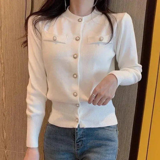 White women's cardigan with decorative buttons, long sleeves, and ribbed hem, paired with jeans