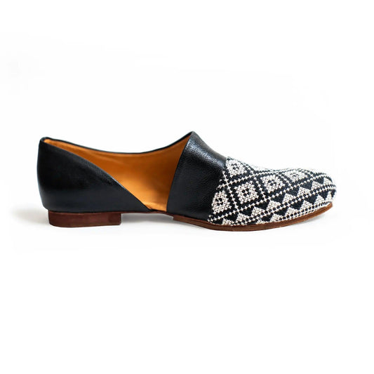 Black and white patterned women's flat loafer with leather accents and low heel, stylish casual footwear