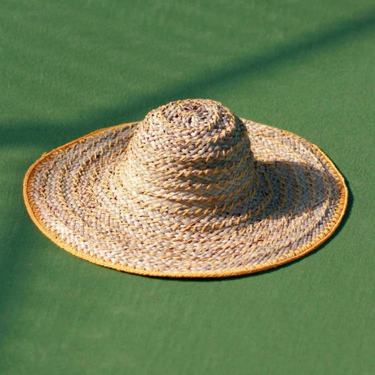 Wide-brimmed woven straw sun hat with yellow trim, perfect for summer fashion and beach outings.