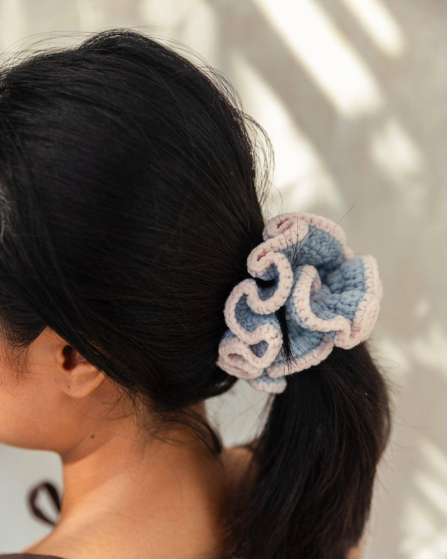 Blue and pink crocheted flower hair scrunchie in dark ponytail, women's fashion accessory