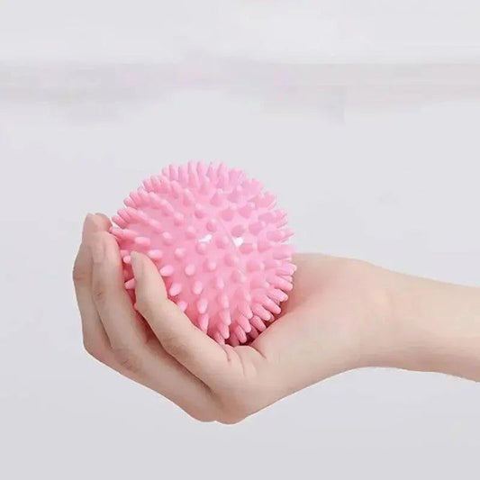 Pink spiky massage ball held in hand for muscle relief and self-care