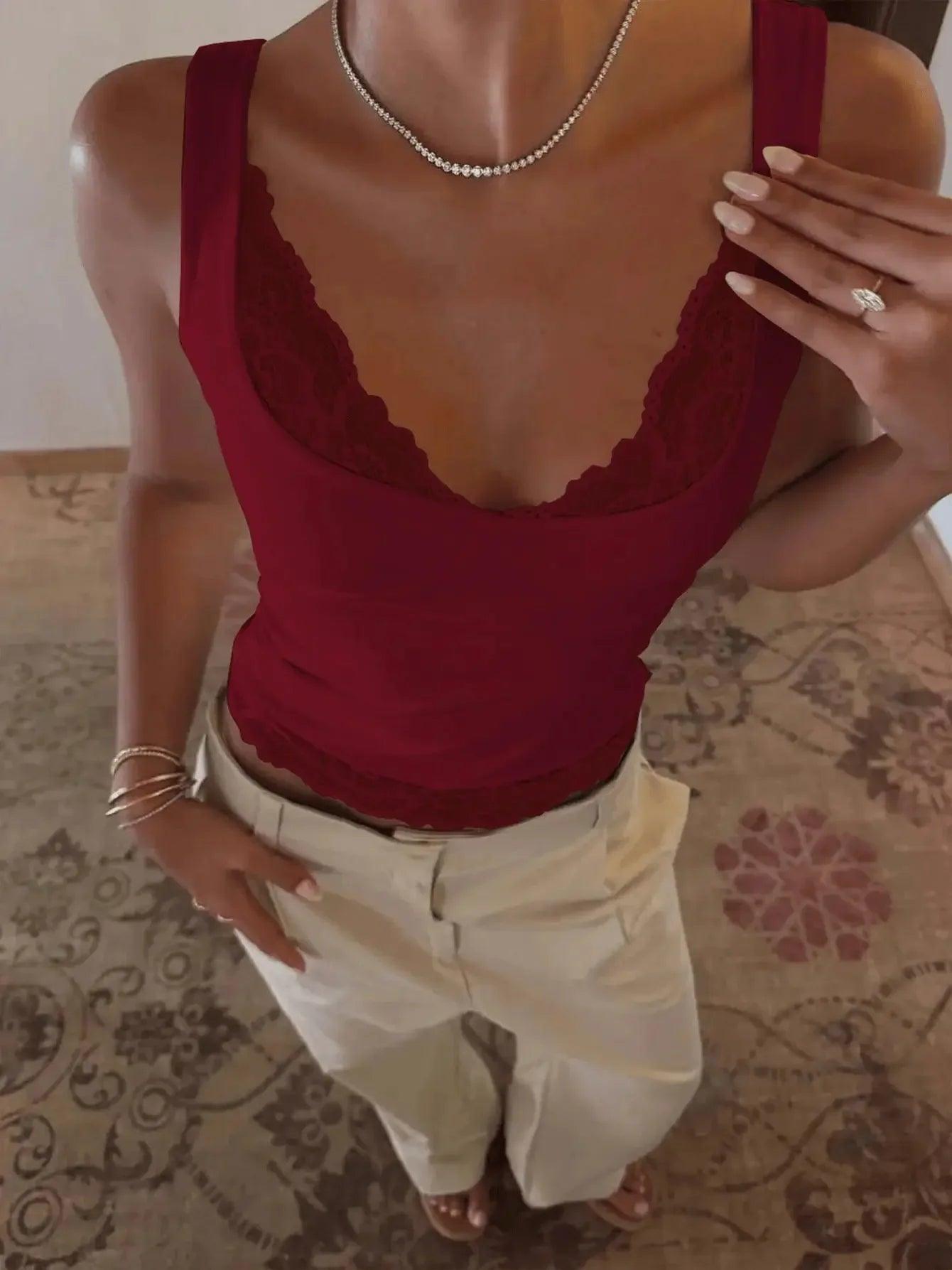 Woman wearing burgundy lace trim tank top with beige pants, styled with necklace and rings for casual fashion