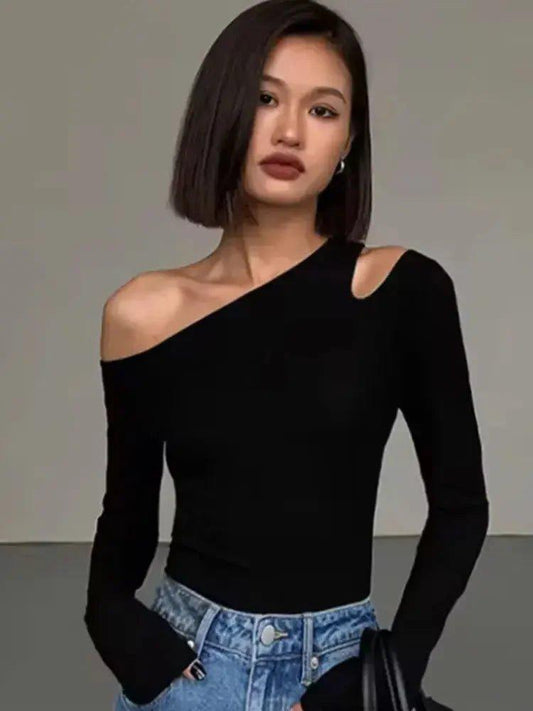 Woman wearing black one-shoulder long sleeve top with blue jeans, stylish fashion outfit