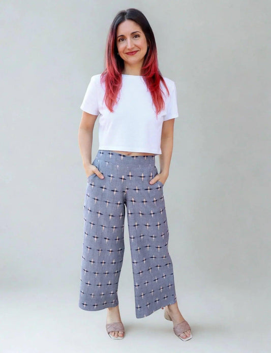 Woman in white crop top and gray patterned wide-leg pants, fashion outfit