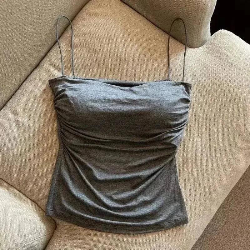 Gray ruched camisole top with thin straps, women's fashion, laid on beige sofa