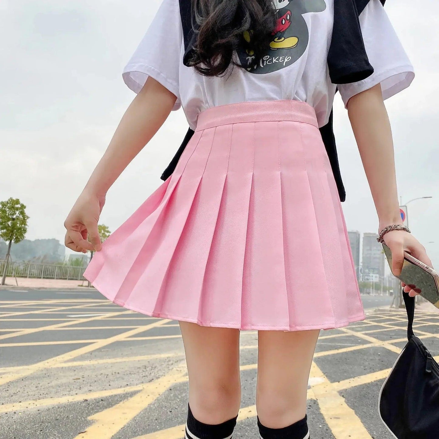 Pink pleated mini skirt with white graphic tee, casual women's fashion outfit