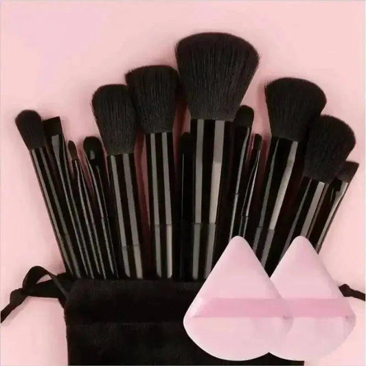 Black makeup brushes with pink beauty sponges in velvet pouch, perfect for women's fashion and beauty routines.
