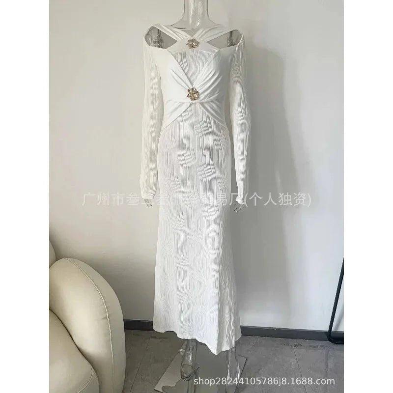 Elegant white long-sleeve women's dress with pleated design and floral embellishments, perfect for fashion events.