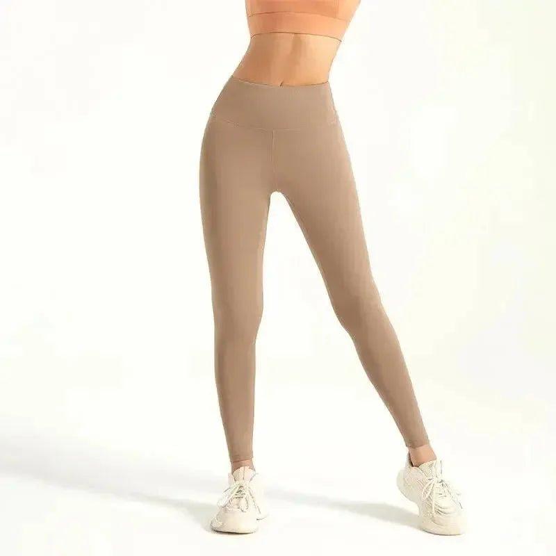 Women's high-waist beige leggings with matching sports bra and white sneakers, fitness fashion