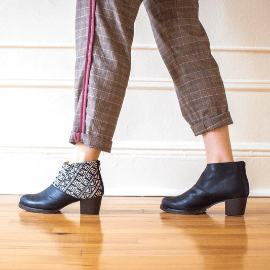 Black ankle boots with geometric pattern, paired with plaid pants, stylish women's fashion footwear