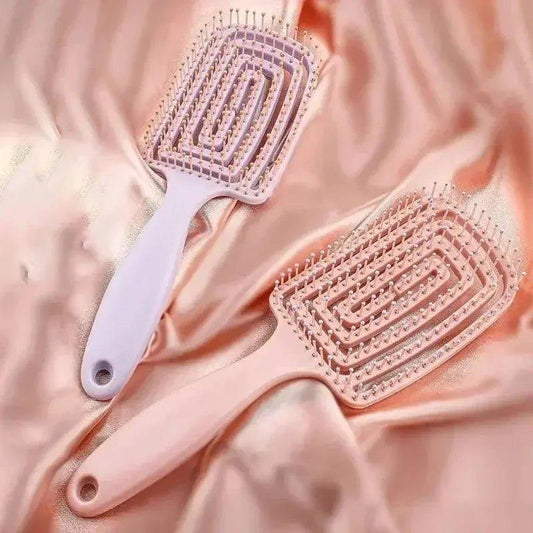 Pink and white detangling hairbrushes on satin fabric for women's beauty and fashion