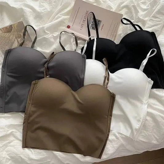 Women's fashion bras in black, white, gray, and olive on a soft bedspread