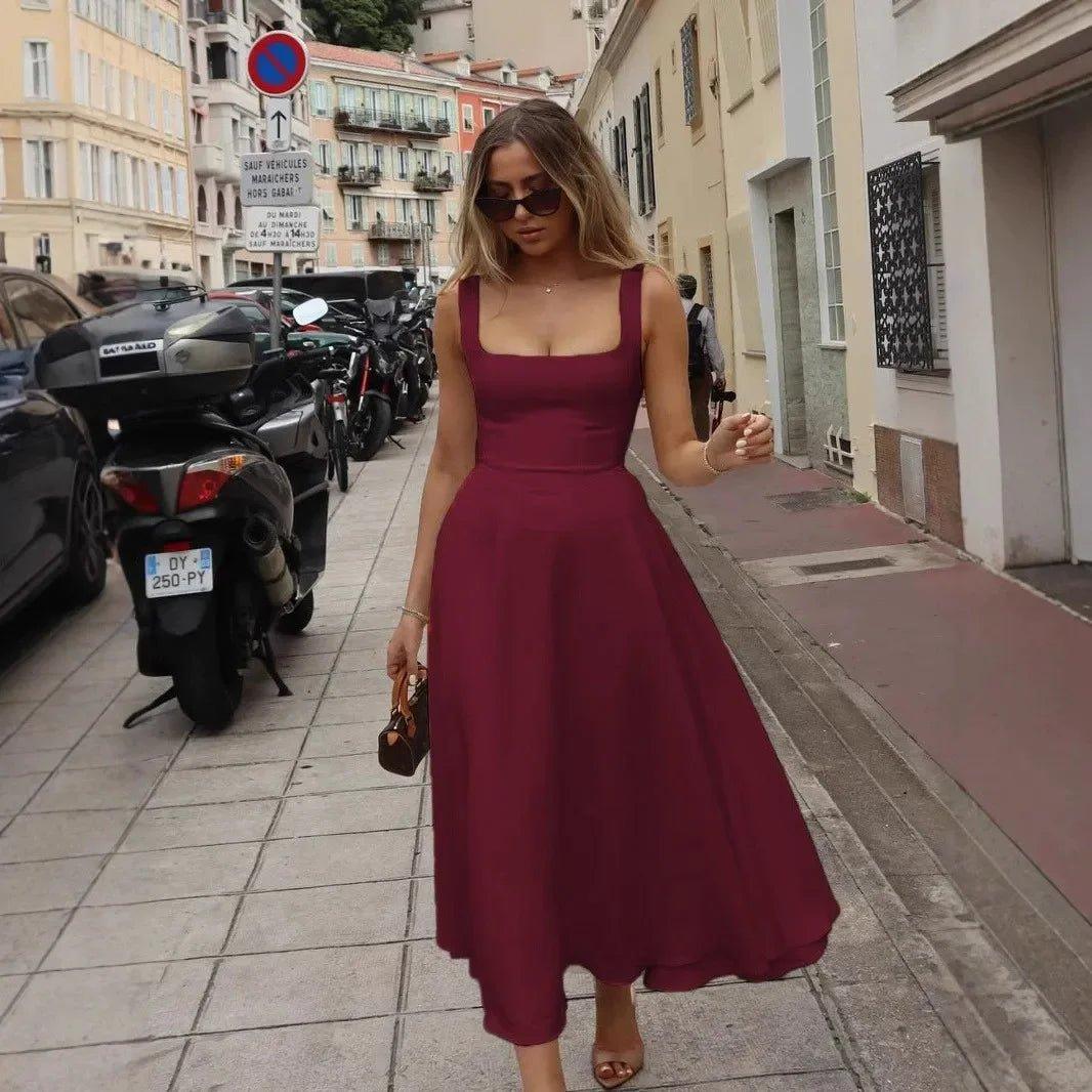 Woman in elegant burgundy midi dress walking city street, fashion style
