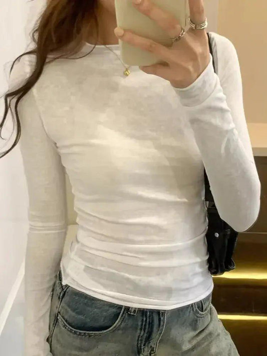 White long sleeve fitted top with ruched detail, paired with denim jeans for casual women's fashion