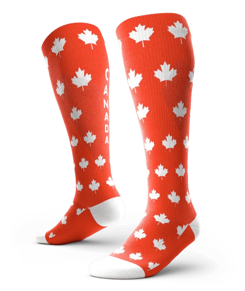 Red knee-high socks with white maple leaves and 'CANADA' text, fashion accessory for women
