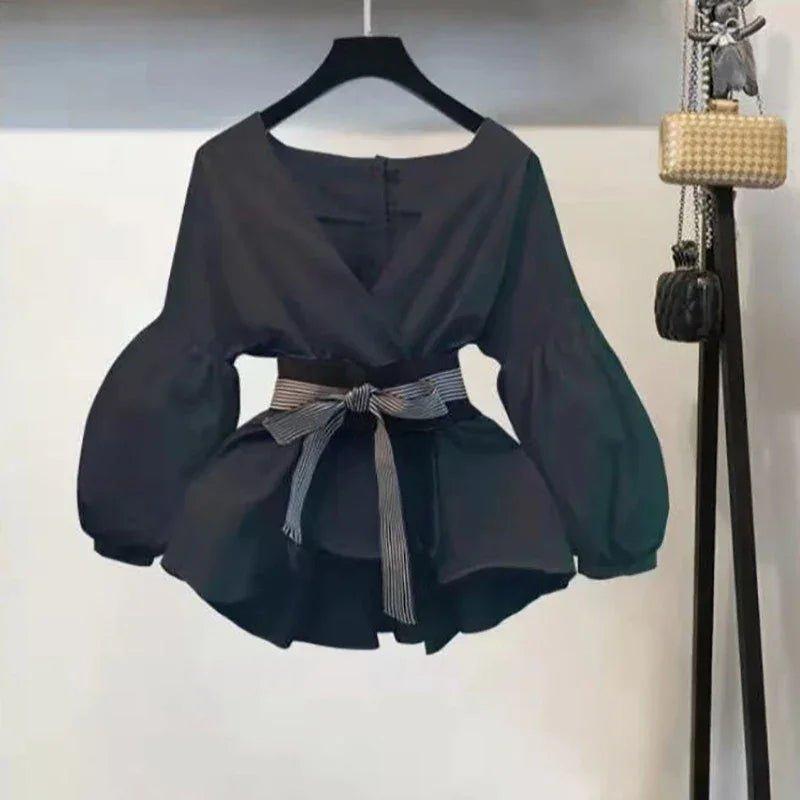 Black women's blouse with puff sleeves, V-neck, and striped belt for stylish fashion look