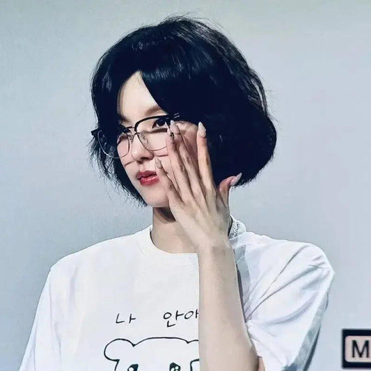 Woman with short black bob haircut wearing glasses and white graphic tee, fashion style