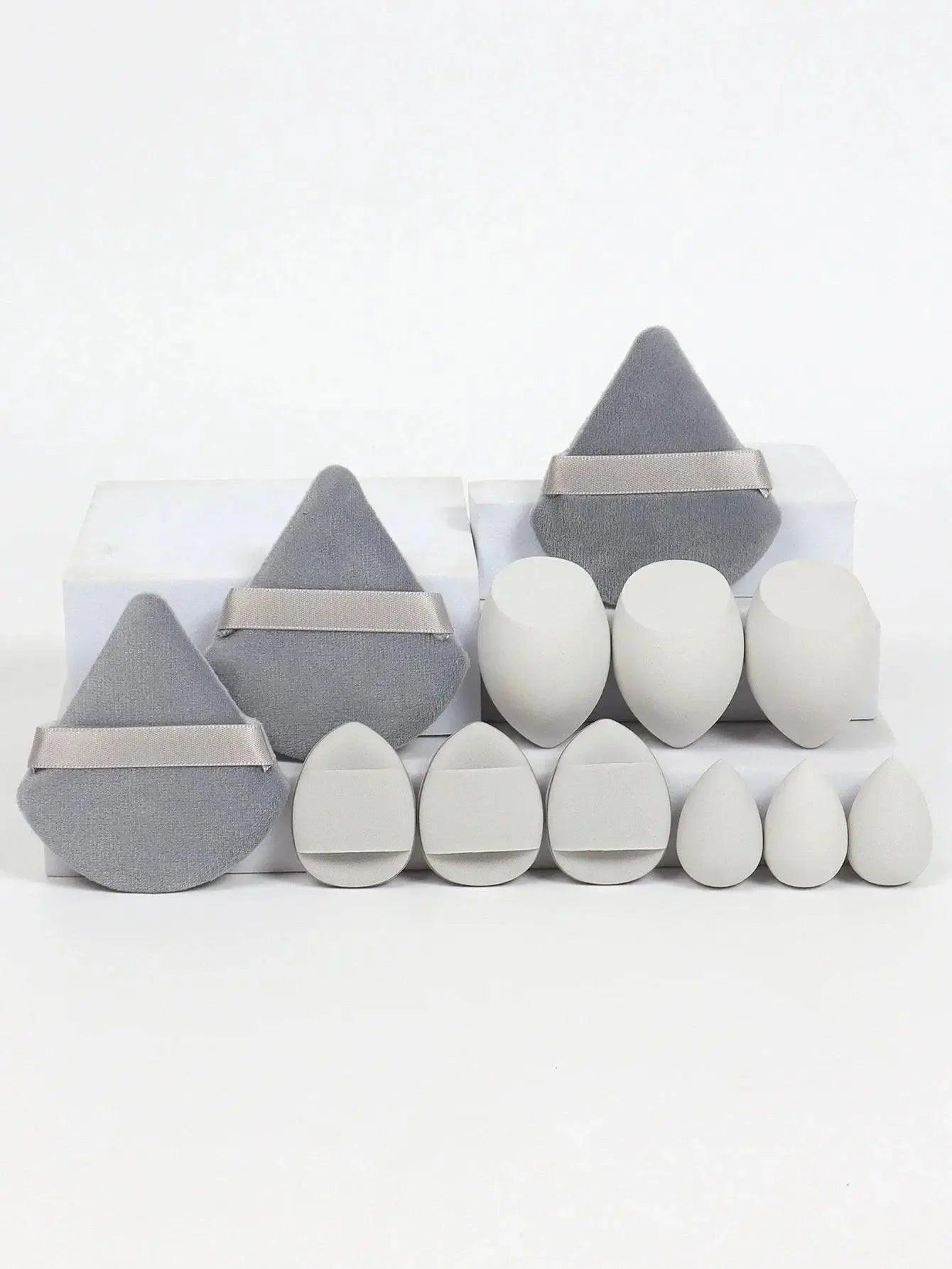 Set of gray and white makeup sponges with velvet pouches, ideal for flawless beauty application