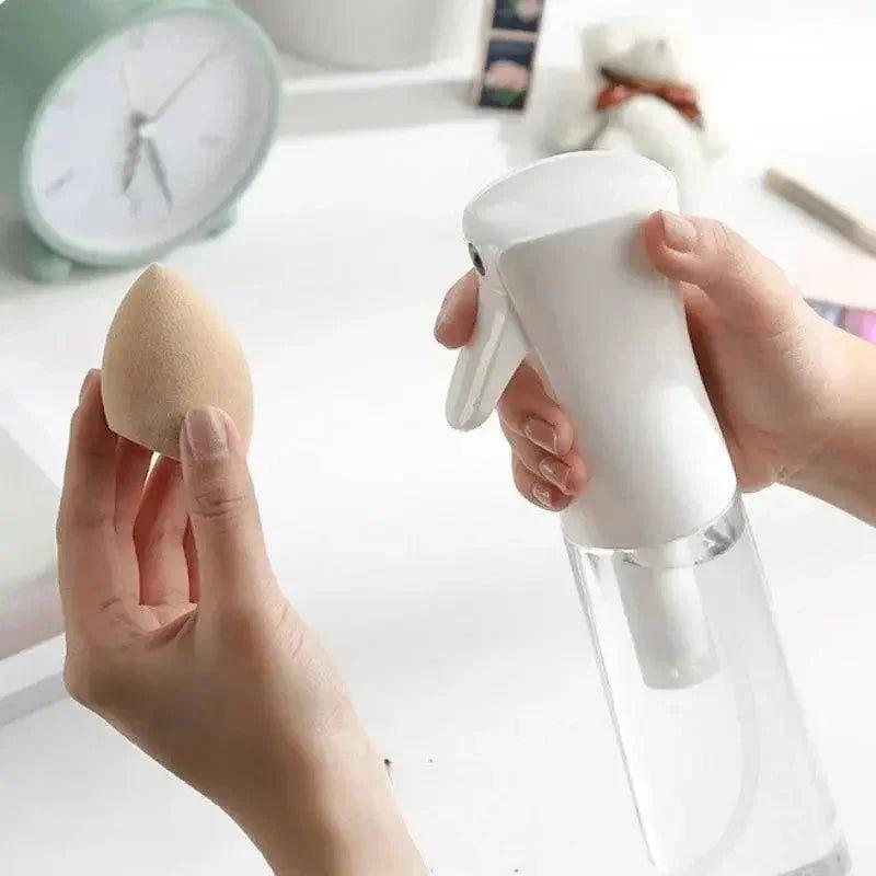 Hand holding makeup sponge and spray bottle for beauty routine