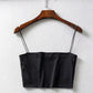 Black satin crop top with thin straps on wooden hanger, women's fashion