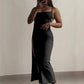 Woman in black slip dress with side slit, taking mirror selfie, stylish fashion outfit