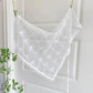 White lace triangle scarf with floral embroidery, delicate pom-pom trim, hanging on door for women's fashion