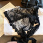 Black lace lingerie with floral pattern, tied bow, styled with handbag and book for women's fashion