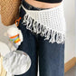 White crochet fringe waist scarf with boho style, paired with denim jeans and straw bag