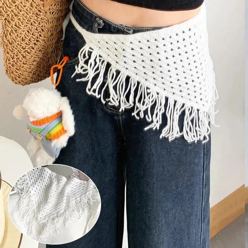 White crochet fringe waist scarf with boho style, paired with denim jeans and straw bag