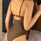 Woman in olive green one-piece swimsuit with adjustable straps and side ruching, back view