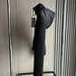 Black women's hooded puffer coat on clothing rack, stylish winter fashion outerwear