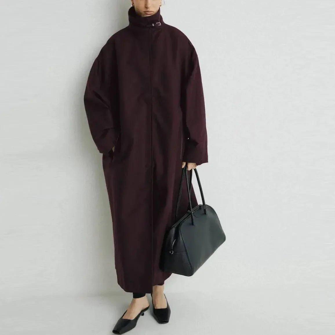 Woman in burgundy oversized coat with black bag and heels, modern fashion look