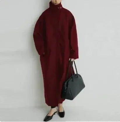 Woman in burgundy oversized coat with black bag and flats, stylish fashion outfit