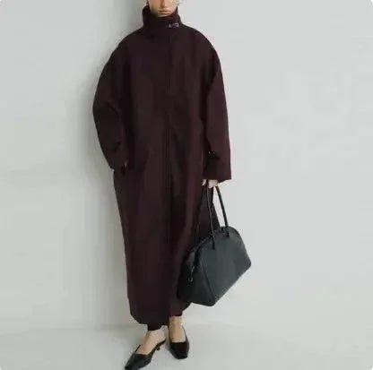 Woman in burgundy oversized coat with black handbag, stylish fashion outfit