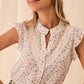 Woman wearing floral print blouse with lace trim and ruffle sleeves, stylish summer fashion top