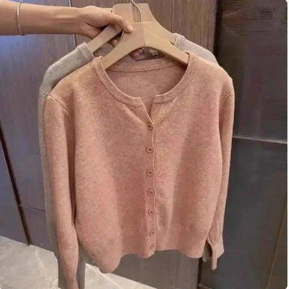 Soft pink women's cardigan sweater with button front, cozy knit, long sleeves, displayed on hanger
