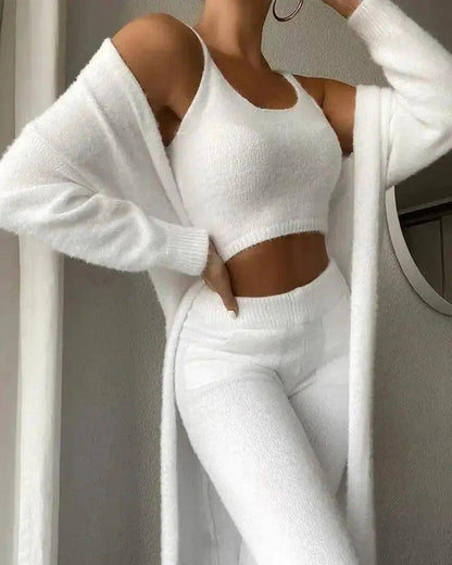 Woman in white knit crop top, matching pants, and open cardigan, stylish cozy fashion outfit