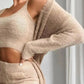 Woman in cozy beige knit crop top and matching pants, off-shoulder style, fashion outfit