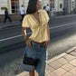 Woman in yellow lace-trim top and denim shorts, stylish streetwear fashion