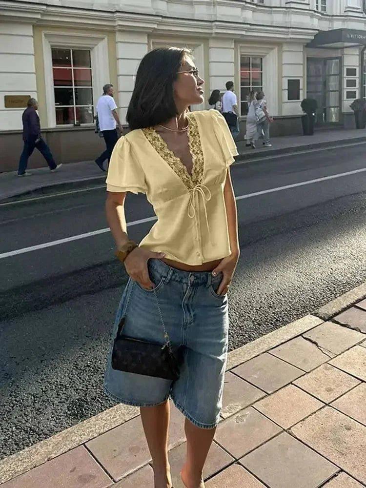 Woman in yellow lace-trim top and denim shorts, stylish streetwear fashion