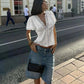 Woman in white lace-trim blouse and denim shorts, street style fashion