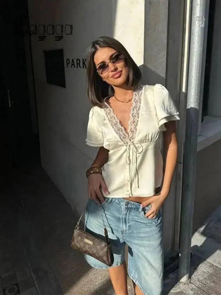Woman in white lace-trim blouse and denim shorts, stylish streetwear fashion