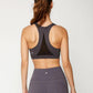 Woman in gray sports bra and leggings, back view, fitness activewear