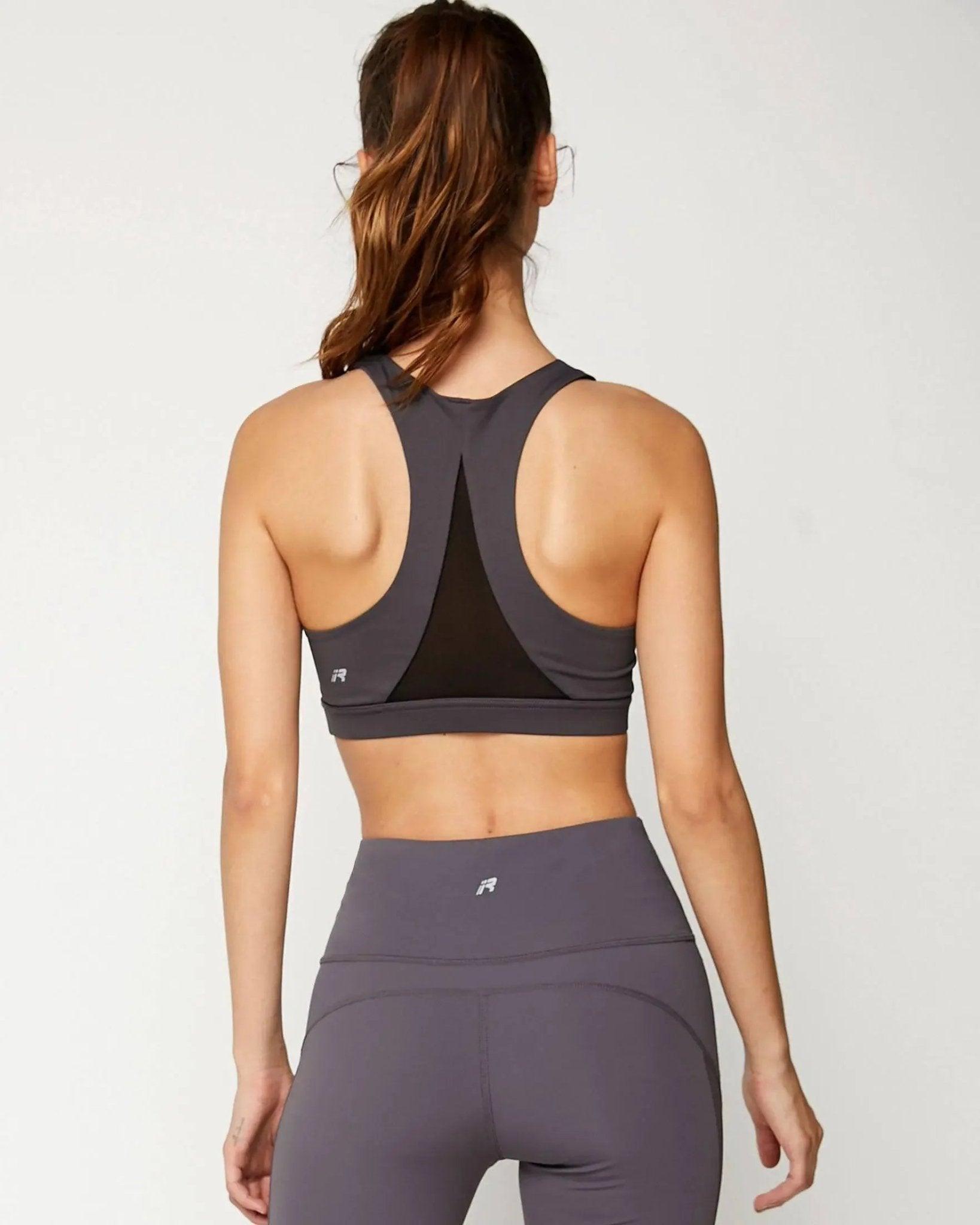 Woman in gray sports bra and leggings, back view, fitness activewear