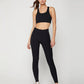 Woman in black sports bra and high-waisted leggings with white sneakers, fitness fashion