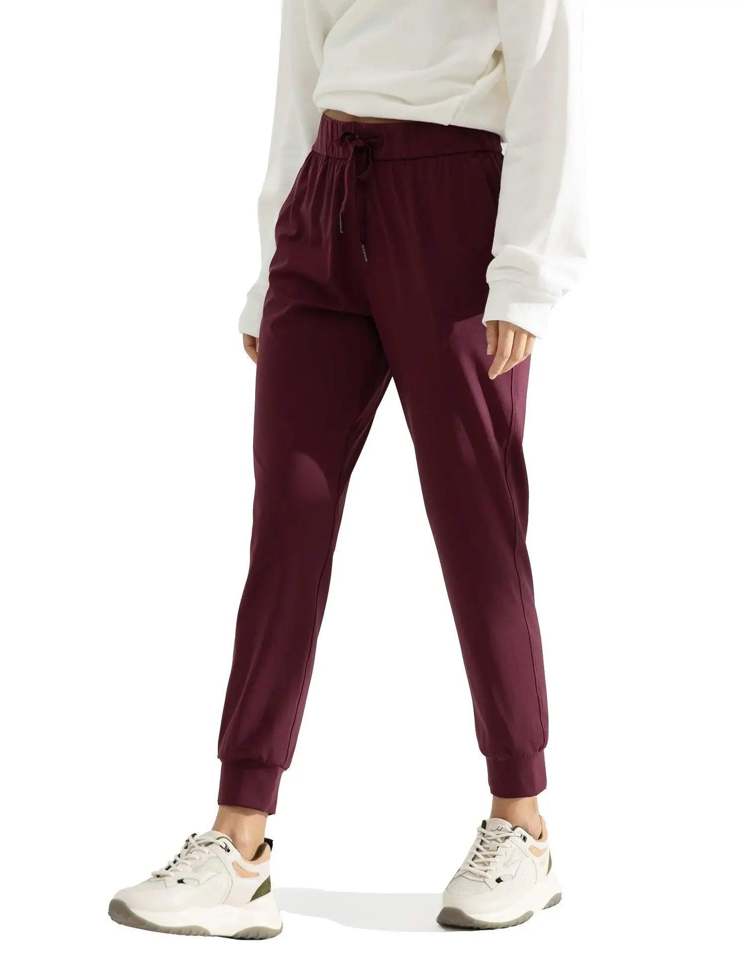 Burgundy drawstring joggers with elastic cuffs, paired with white hoodie and sneakers for casual women's fashion
