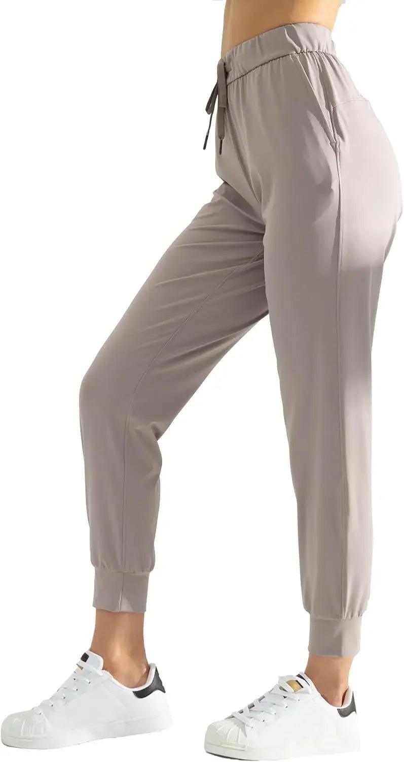 Women's gray jogger pants with drawstring waist, paired with white sneakers for casual fashion