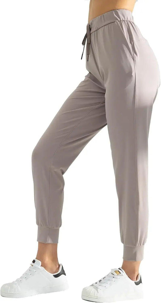 Women's gray jogger pants with drawstring waist, paired with white sneakers for casual fashion