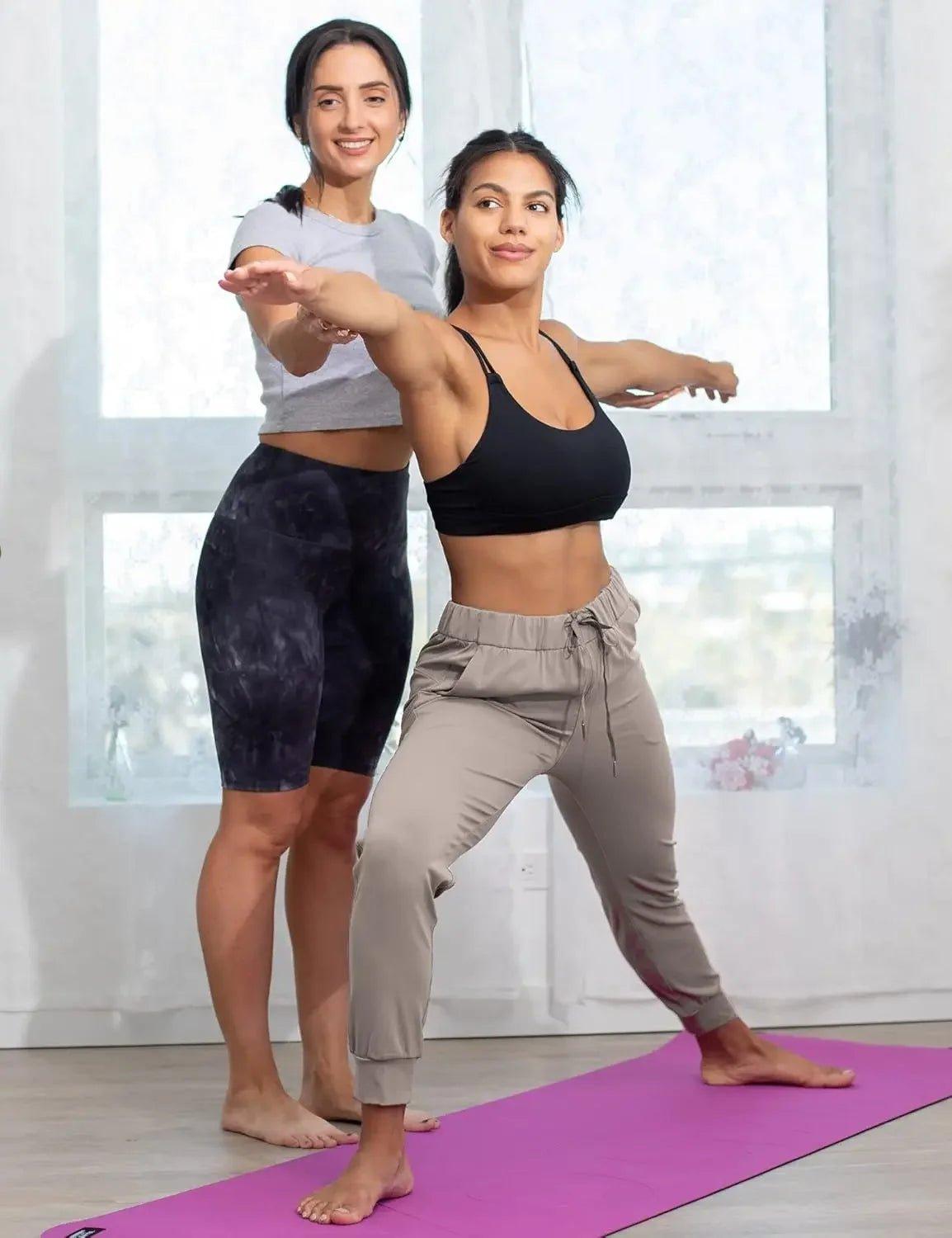 Women in activewear doing yoga pose on purple mat, fitness fashion